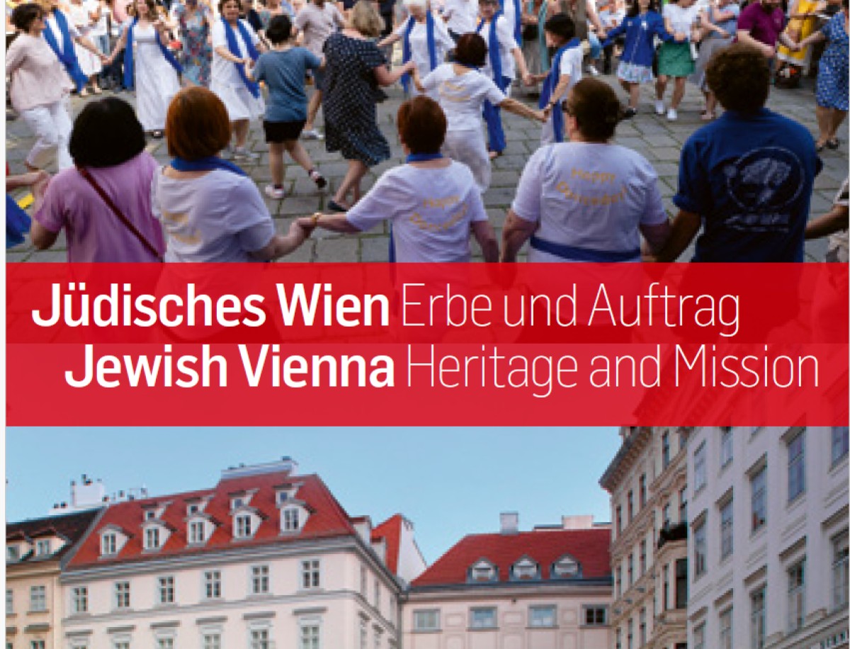 Tanzende Menschen vor Wiener Altbauten: Menschen halten sich an den Händen und tanzen in einem Kreis auf gepflastertem Platz vor historischen Gebäuden