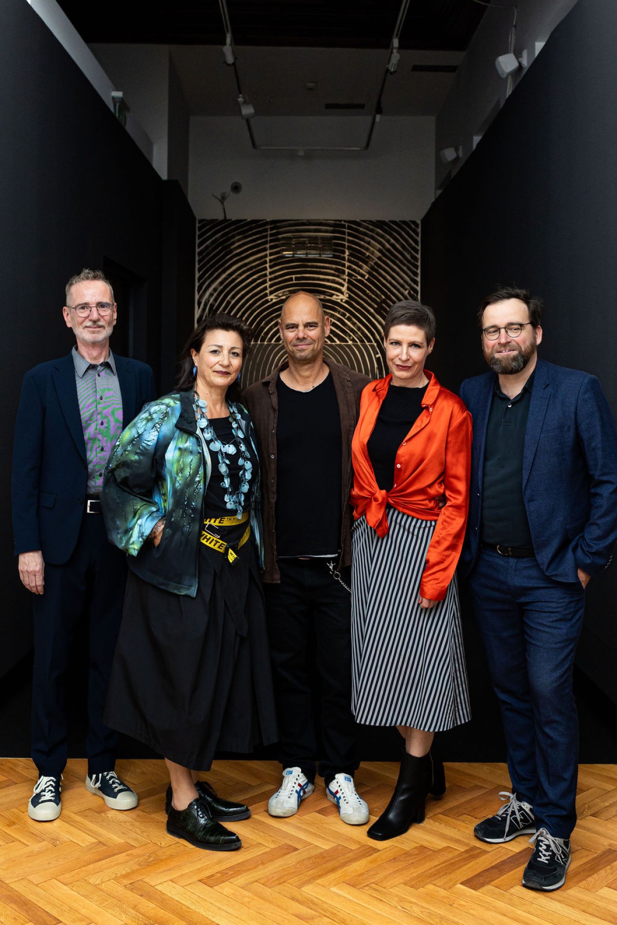 : five persons in from of a dark background