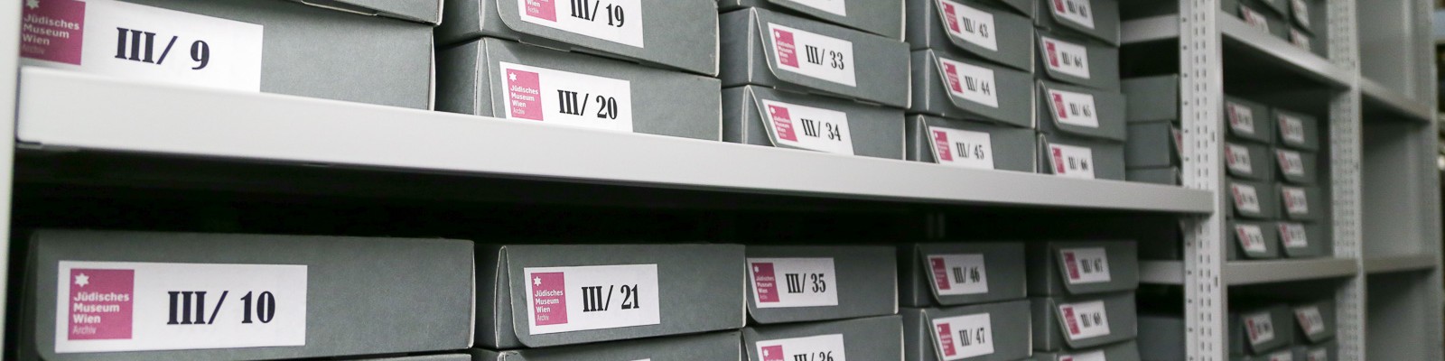 Archivboxen im Jüdischen Museum Wien Regal mit grauen Archivboxen des Jüdischen Museums Wien, beschriftet mit Nummern von III/7 bis III/49